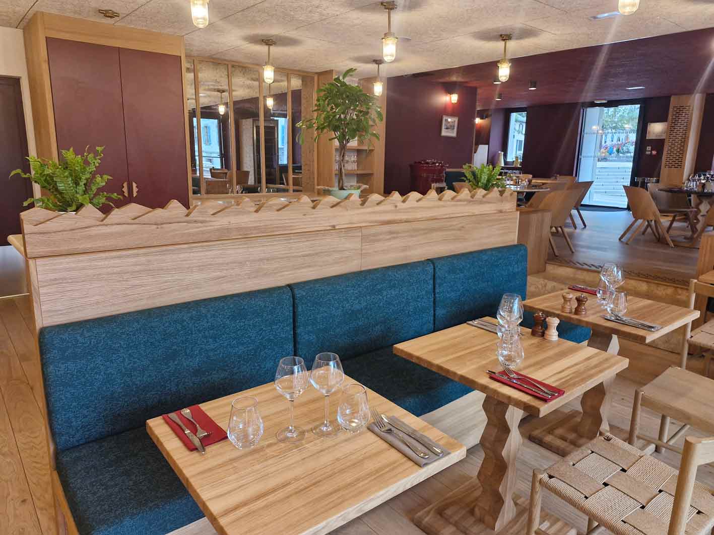 tables en bois et banquettes en bois et tissu bleu dans le restaurant de la Couronne à Chamonix74